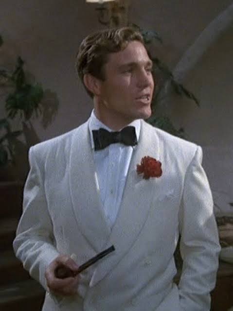 正裝定義中的 Black Tie 變化：一位男士穿著白色或淺色雙排釦無尾禮服（Tuxedo），展現夏季或度假的正式風格。